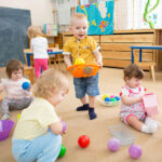 Group of kids playing with balls in kindergarten or day care centre